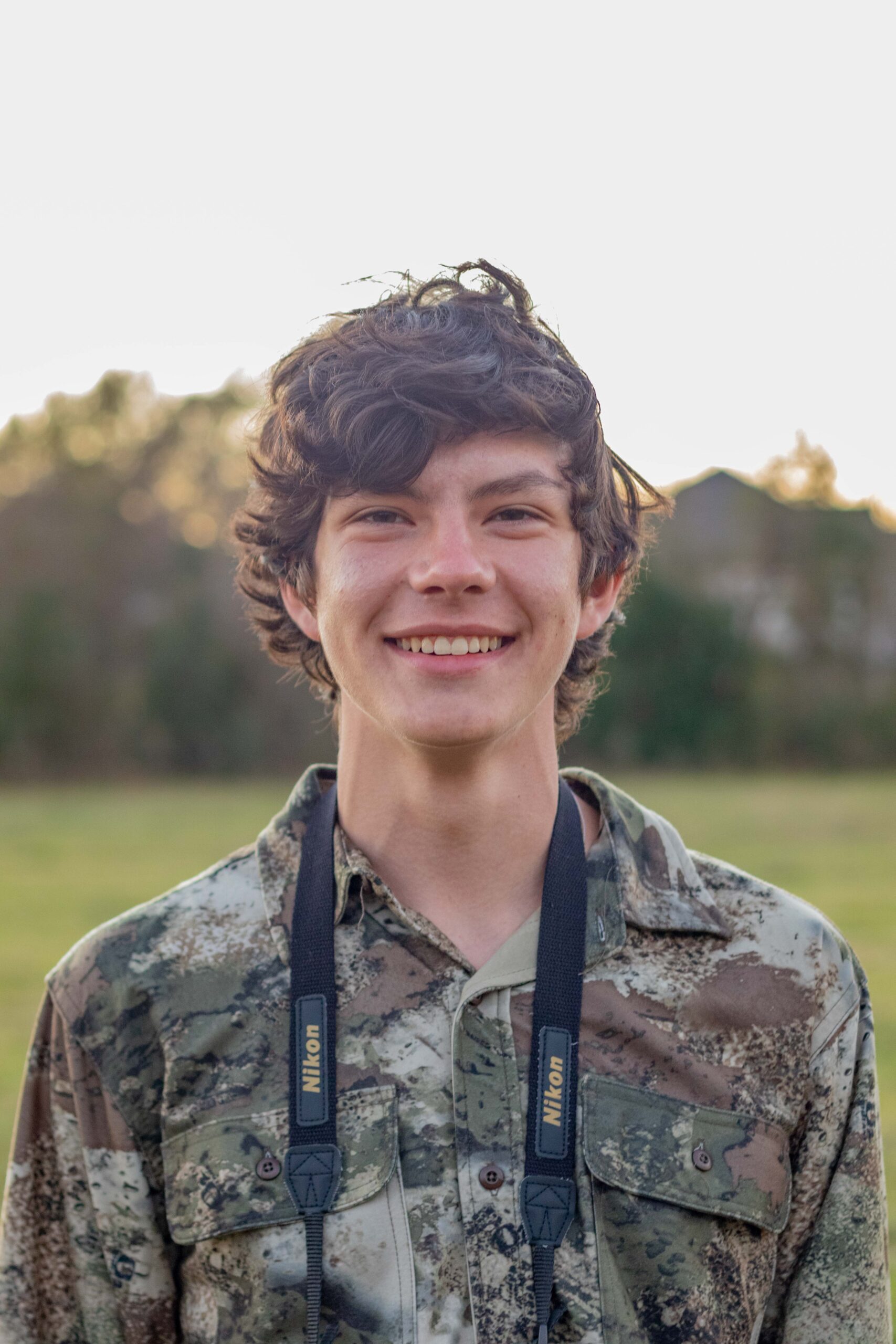 Young man with binoculars around his neck.